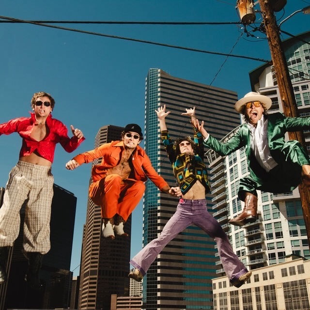 The Dirty Turkeys jumping in front of Denver skyline